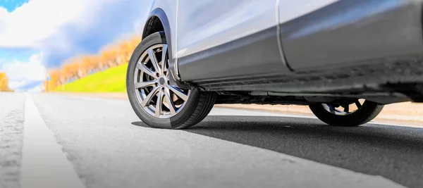 Wheel of Car on asphalt road in summer, standing on the Road Beautiful day at Countryside green forest, nature street with copyspace