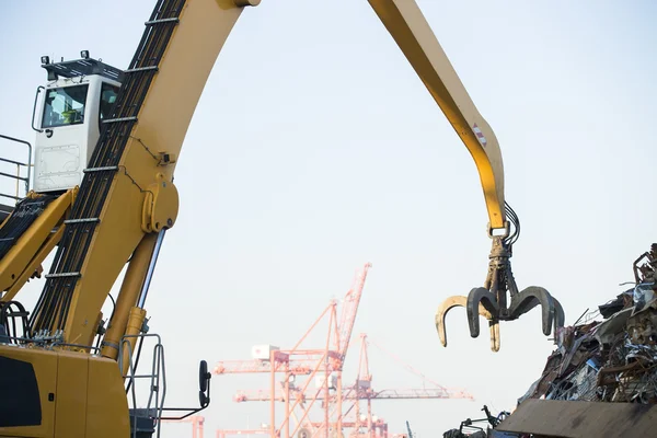 Crane grabber loading metal rusty scrap in the dock Royalty Free Stock Photos