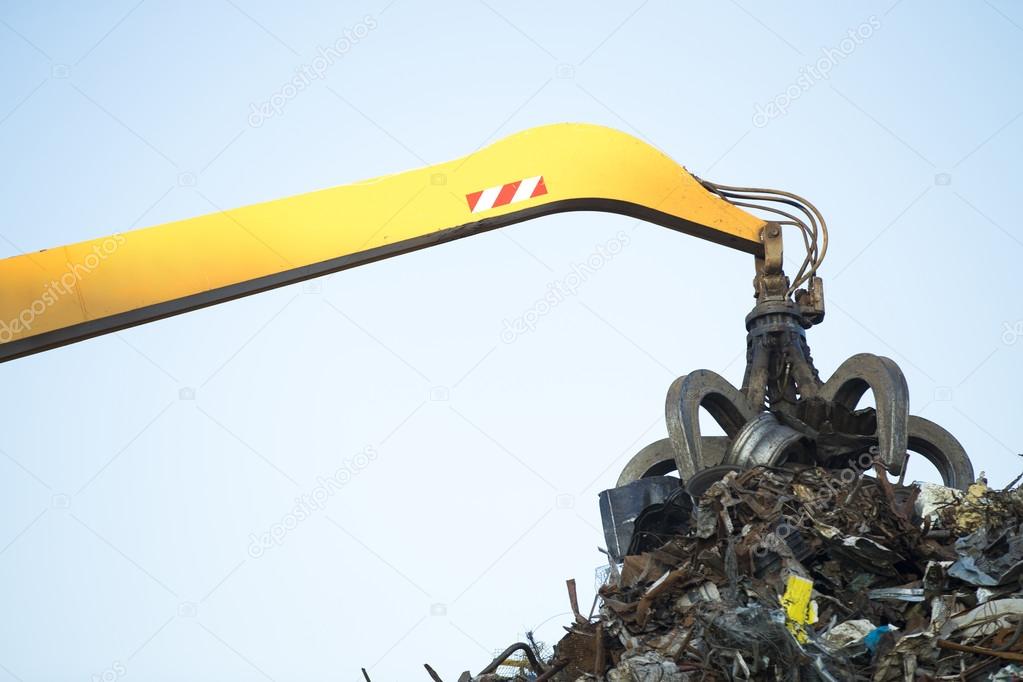 Large tracked excavator working a steel pile at a metal recycle 