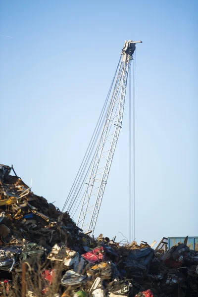 Kraan klauw op de top van stapel met schroot in recycling center — Stockfoto