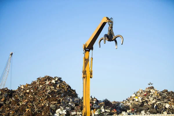 Kraan klauw op de top van stapel met schroot in recycling center — Stockfoto