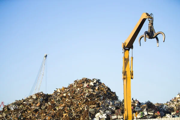 Garra guindaste no topo da pilha com sucata de metal no centro de reciclagem — Fotografia de Stock