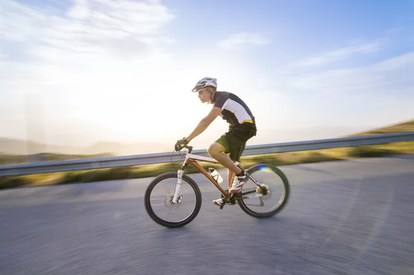 Hombre ciclista montando bicicleta de montaña en un día soleado en un camino de montaña —  Fotos de Stock