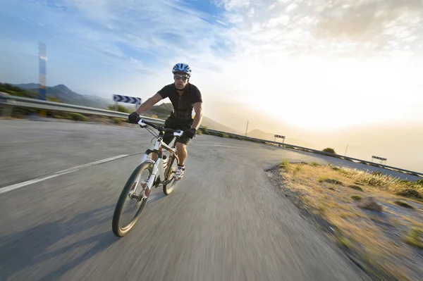 Fietser man paardrijden mountainbike in zonnige dag op een bergweg — Stockfoto