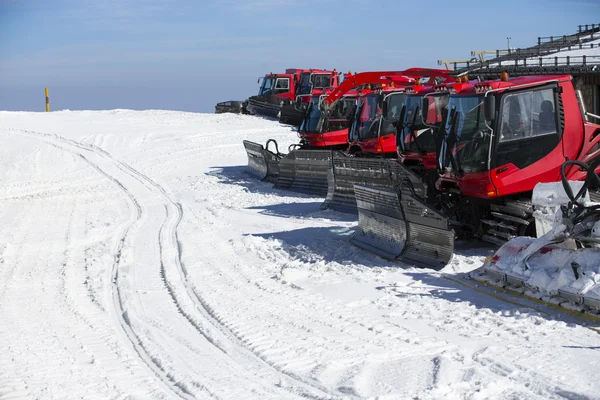 Grupo de Snow-grooming máquina na colina de neve pronto para esqui slo — Fotografia de Stock