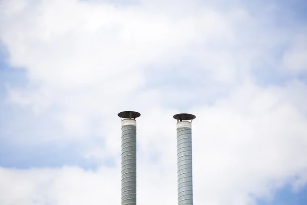 Dois tubos de ventilação sobre o céu azul closeup — Fotografia de Stock