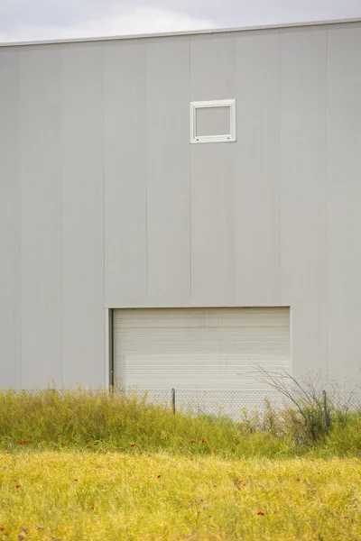 Industribyggnad nära fält och blå himmel — Stockfoto