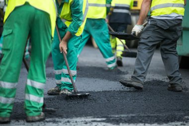 asfalt finişer makine yol yapımı sırasında işletim ve onarma işçi çalışıyor