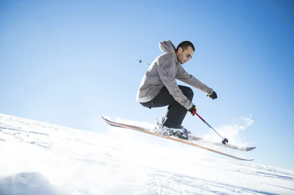 Saltador de esquí freestyle con esquís cruzados en montañas nevadas — Foto de Stock