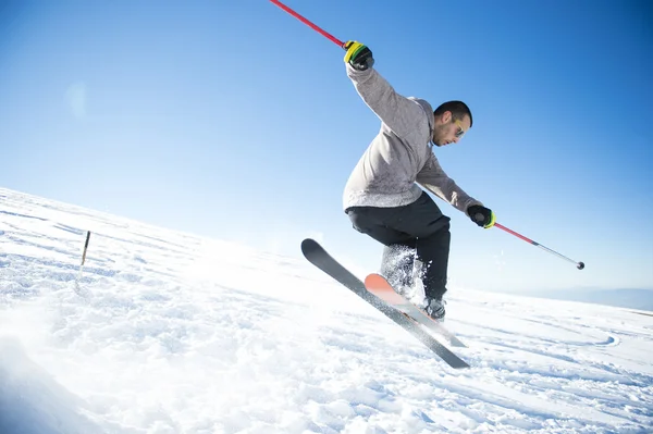 Freestyle ski jumper with crossed skis in snowy mountains — Stock Photo, Image