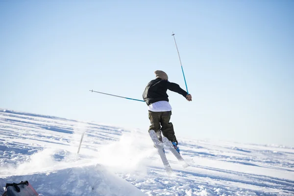 Saltador de esqui Freestyle com esquis cruzados em montanhas nevadas — Fotografia de Stock