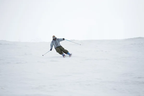 Esquiador en las montañas, preparado pista y día soleado — Foto de Stock