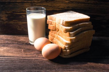 dilim ekmek, yumurta ve süt ahşap arka plan üzerinde