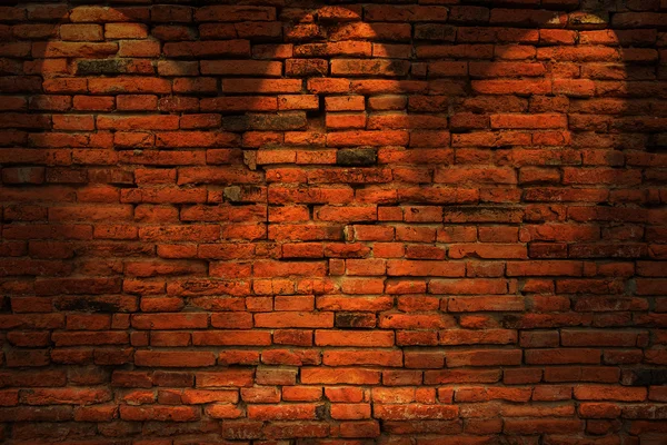 Low-Key-Foto der roten Backsteinmauer lizenzfreie Stockfotos