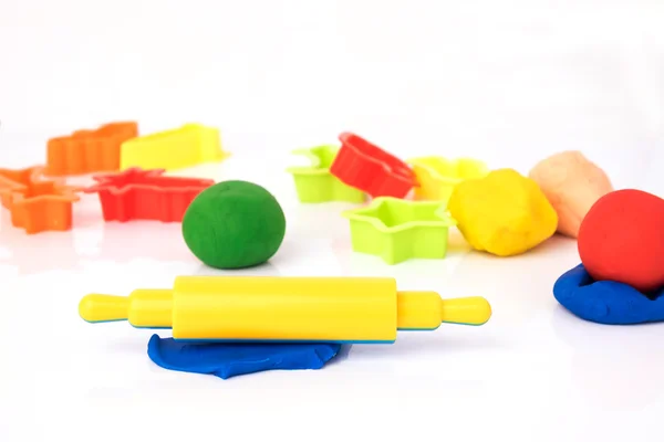 Oyun hamuru ve beyaz arka plan üzerinde plastik kesme blok