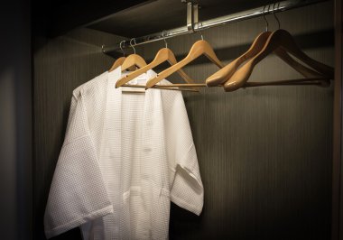 siyah dolap ahşap askıları ile beyaz bornoz