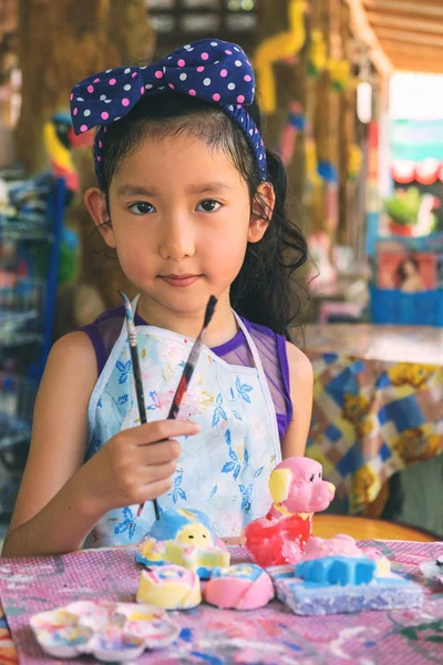 Мила азіатська дівчина показує її пензлик для фарби . — стокове фото