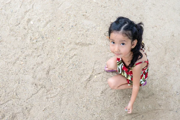 Linda niña jugando con arena en el patio . — Foto de Stock