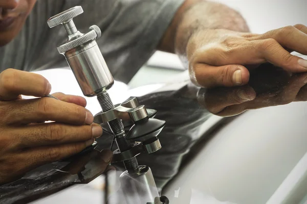 Un uomo che utilizza attrezzature di riparazione per riparare il parabrezza danneggiato — Foto Stock