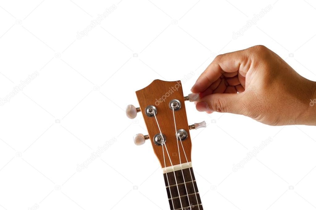 Hand tuning ukulele on white background