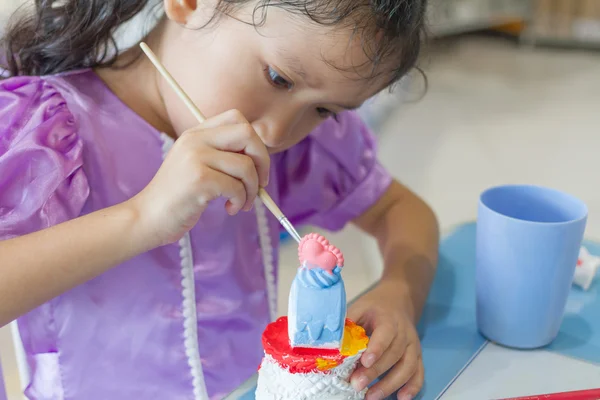 Крупный план ребенка, рисующего цвет на штукатурке статуи — стоковое фото