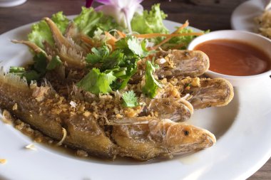 Balık sarımsak ve çanak üzerinde taze sebze ile ateş