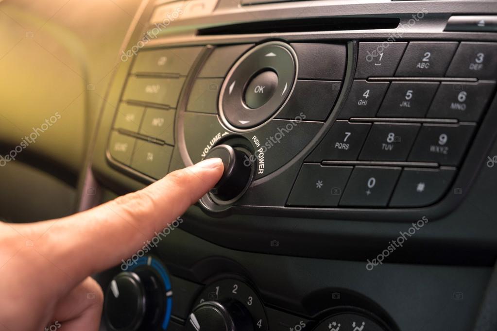 Hand Pushing the power button to turn on the car stereo system — Stock