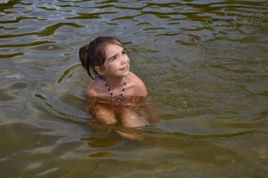 Küçük kız nehirde yüzmeye çalışıyor, yaz, sıcak, su
