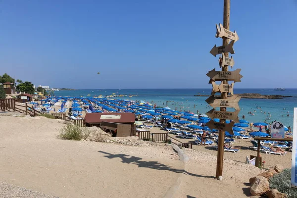 Wooden signpost with distance markers on the beach of Fig tree bay in Protaras