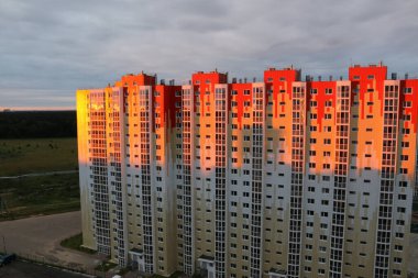 Şehirde gün batımı, güneş ışınları çok katlı bir binaya düşüyor.