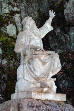 Elini beyaz mermerden kaldırmış yaşlı bir adamın heykeli.