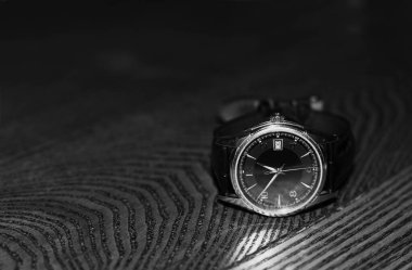 Saat ahşap bir yüzeye yerleştirilmiş. Siyah beyaz fotoğraf.