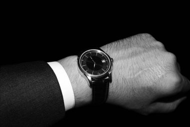 Klasik bir takımla klasik bir kol saati. Siyah beyaz fotoğraf