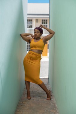 İki duvar arasında duran kendinden emin genç bir kadın.