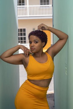 Kollarıyla duvara yaslanan kendinden emin genç bir kadın.