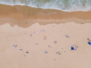 Güneş banyosu yapan bir grup insanın hava görüntüsü