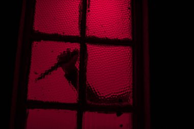 Bıçak tutan kişinin silueti pencereden görülüyor.