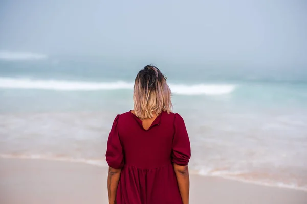 Vista trasera de la mujer de pie y mirando el océano — Foto de Stock