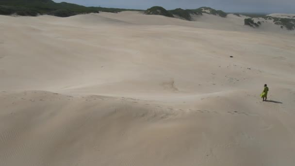 Drone vista de la mujer caminando a lo largo de duna de arena — Vídeos de Stock