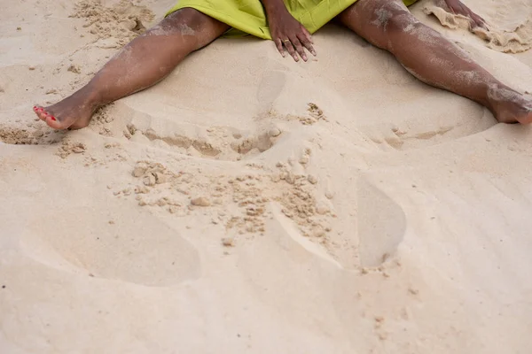 Midsection skud af kvinde sidder på sand på stranden - Stock-foto