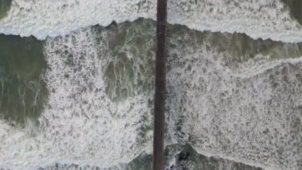 Высокий угол обзора беспилотника, летящего над пирсом с увиденными волнами — стоковое видео
