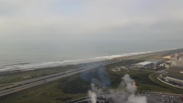 Drone lowering from sky and flying past smog seen from factory — Stock Video