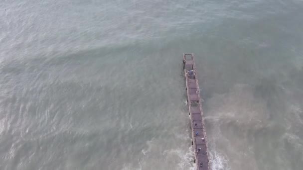 Drohne steigt auf und zeigt Seebrücke mit Wellen — Stockvideo