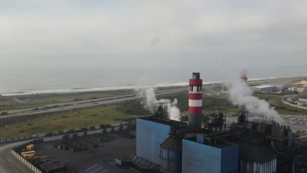 Légi felvétel arról, ahogy a drón elrepül a gyárból, ami füstöt ereszt a levegőbe. — Stock videók