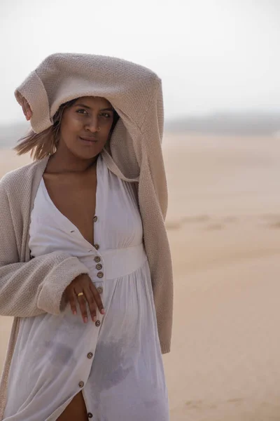 Nahaufnahme Porträt einer Frau auf Sanddünen, die ihren Kopf mit Ärmeln bedeckt — Stockfoto