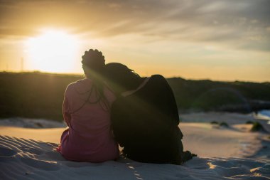 Güneşin doğuşunu izleyen iki kadın.