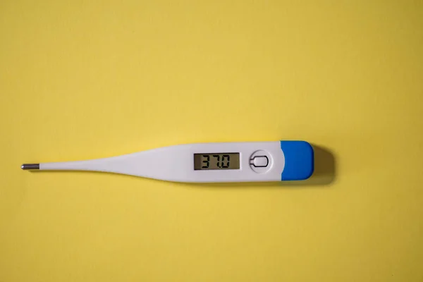 Digital thermometer isolated against yellow background