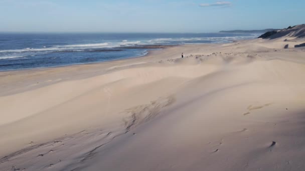 Drone volando sobre mujer eso es caminar a lo largo de dunas de arena — Vídeos de Stock
