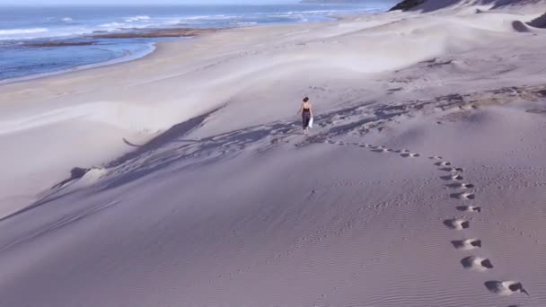 Légi felvétel a homokdűnék mentén sétáló nőről — Stock videók