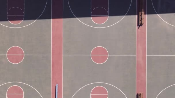 Drone panoramique loin d'une rangée de terrains de basket-ball — Video